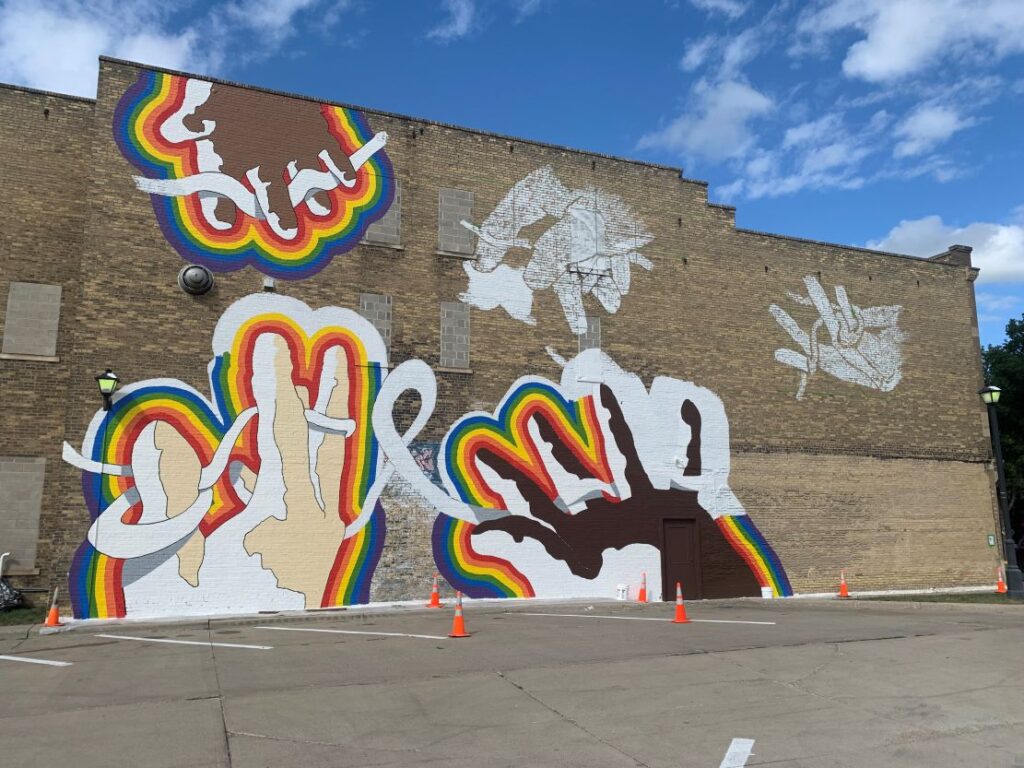 DIVERSITY AND UNITY MURAL BEING PAINTED BY TREY EVERETT IN DOWNTOWN CROOKSTON
