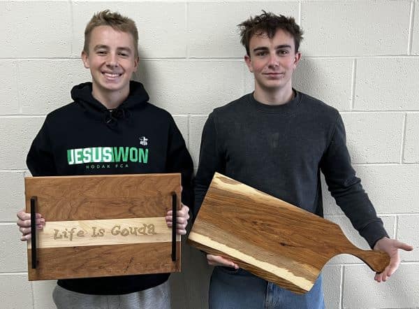CHS students Gunnar Groven and Cade Wisk make charcuterie boards for United Way auction